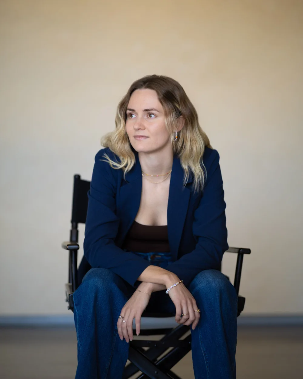 Bre in a director's chair, looking off camera