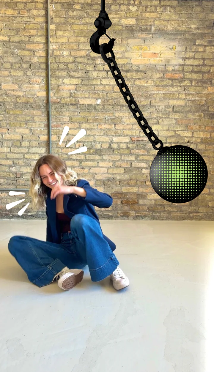 Edited photo of Bre knocked to the floor by a cartoon wrecking ball