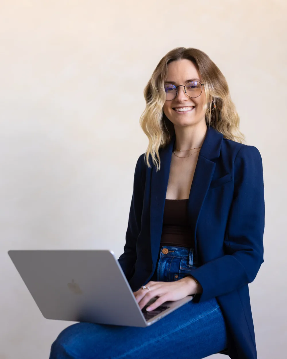 Bre Blesi of Snack Club, smiling at her laptop