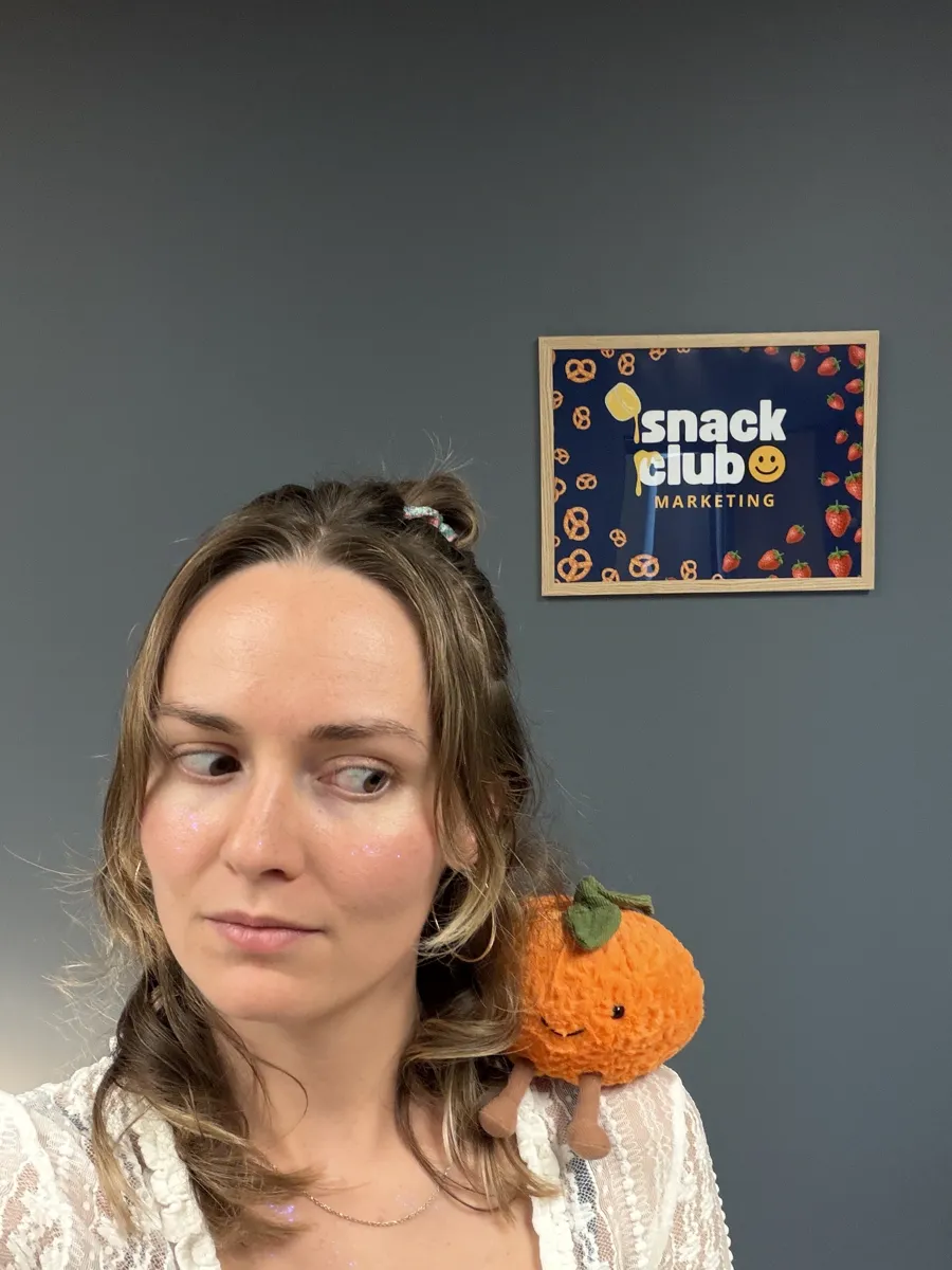 Bre giving side-eye to a plush orange on her shoulder