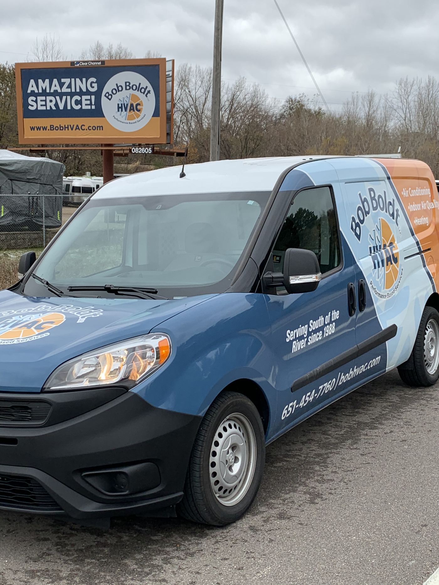 A Bob Boldt HVAC van parked in front of the company's billboard